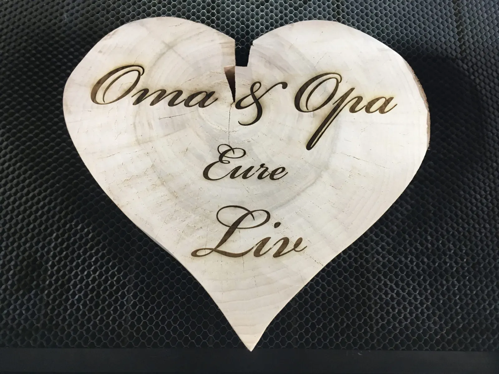 Holzherz aus einer Baumscheibe mit der Gravur „Oma & Opa, Eure Liv“